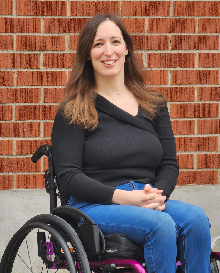 Leanne is a white woman sitting in a purple wheelchair